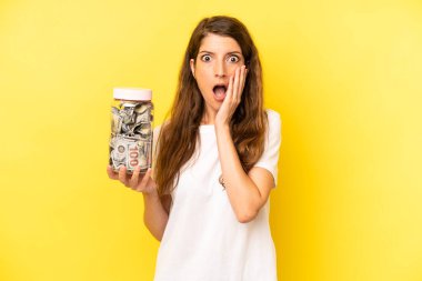 pretty caucasian woman feeling shocked and scared. dollar banknotes savings