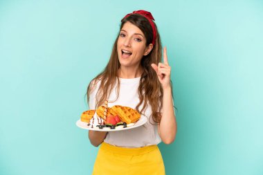 pretty caucasian woman feeling like a happy and excited genius after realizing an idea. home made waffles concept