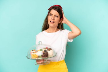 Kafkasyalı bir kadın stresli, endişeli ya da korkmuş, elleri başının üstünde. Ev yapımı kek konsepti