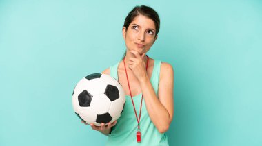 pretty caucasian woman thinking, feeling doubtful and confused. soccer trainer concept