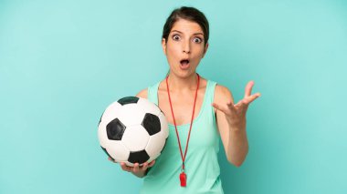 pretty caucasian woman feeling extremely shocked and surprised. soccer trainer concept