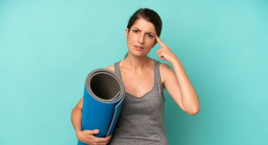 pretty caucasian woman feeling confused and puzzled, showing you are insane. fitness and yoga concept