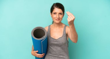 pretty caucasian woman making capice or money gesture, telling you to pay. fitness and yoga concept