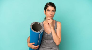 pretty caucasian woman thinking, feeling doubtful and confused. fitness and yoga concept