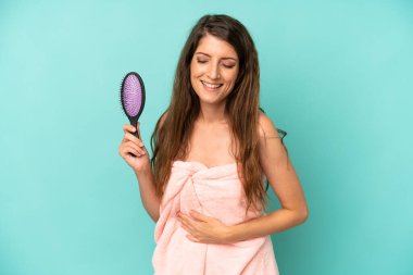 Kafkas bir kadın komik bir şakaya yüksek sesle gülüyor. saç tarağı konsepti