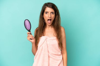 Kafkasyalı bir kadın çok şaşırmış ya da şaşkın görünüyor. saç tarağı konsepti