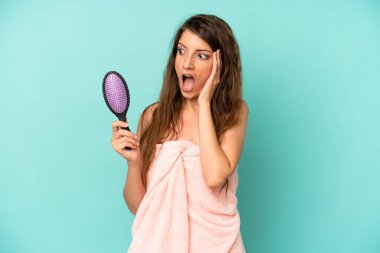 Kafkasyalı bir kadın mutlu, heyecanlı ve şaşırmış hissediyor. saç tarağı konsepti