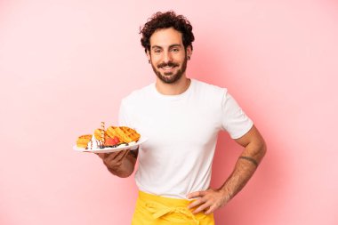 Çılgın sakallı adam mutlu bir şekilde gülümsüyor, eli kalçasında ve kendinden emin. Waffle konsepti