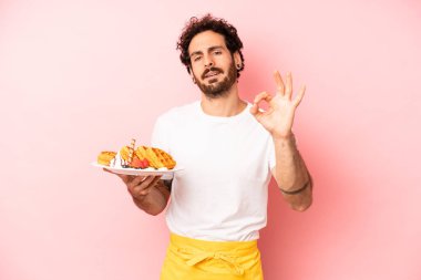 Çılgın sakallı adam kendini mutlu hissediyor, iyi bir jestle onaylıyor. Waffle konsepti