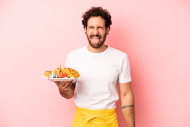Çılgın sakallı, neşeli ve asi tavırlı, şaka yapan ve dilini dışarı çıkaran bir adam. Waffle konsepti