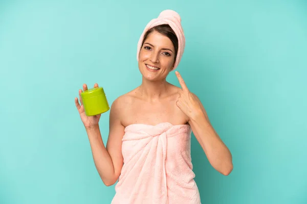 pretty caucasian woman smiling confidently pointing to own broad smile. shower and gel concept