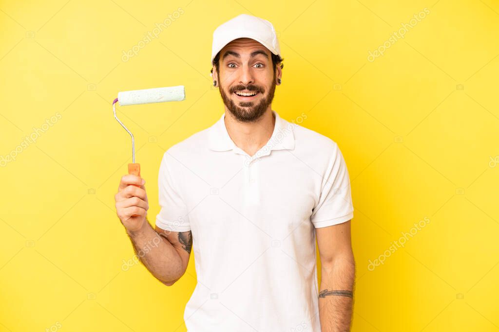 crazy bearded man looking happy and pleasantly surprised. painting home concept