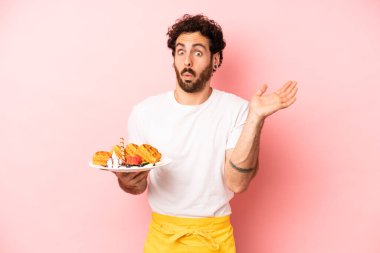 Çılgın sakallı adam şaşırmış ve şok olmuş görünüyor. Çenesi düşmüş ve elinde bir nesne var. Waffle konsepti