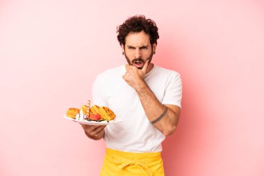 Ağzı ve gözleri açık, elleri çenesinde çılgın sakallı adam. Waffle konsepti