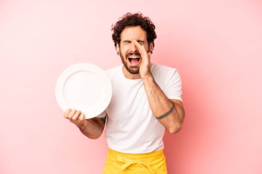 Çılgın sakallı adam mutlu hissediyor, elleri ağzının kenarında bağırıyor. Tabak taşıyan hizmetçi.