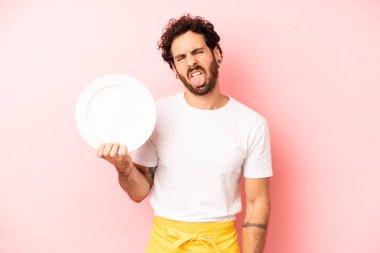 Çılgın sakallı adam iğreniyor, sinirleniyor ve dili dışarı çıkıyor. Tabak taşıyan hizmetçi.