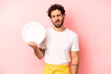 Çılgın sakallı adam şaşkın ve şaşkın hissediyor. Tabak taşıyan hizmetçi.