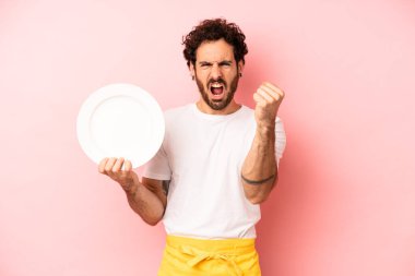 Çılgın sakallı adam sinirli bir ifadeyle agresif bir şekilde bağırıyor. Tabak taşıyan hizmetçi.