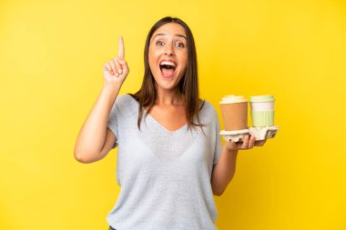 İspanyol genç yetişkin kadın bir fikri fark ettikten sonra mutlu ve heyecanlı bir dahi gibi hissediyor. kahve konseptini kaldır.