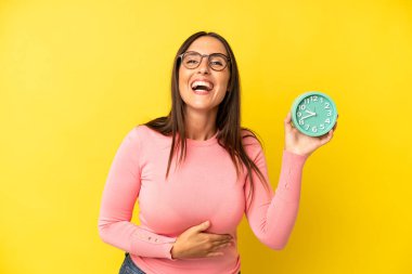 Latin kökenli genç bir kadın komik bir şakaya yüksek sesle gülüyor. Alarm saati kavramı