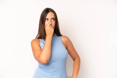 Hispanik güzel kadın ciddi, düşünceli ve endişeli, elleri çenesine bastırılmış şekilde yan bakıyor