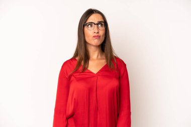 İspanyol güzel kadın şaşkın ve şaşkın görünüyor, merak ediyor veya bir sorunu çözmeye çalışıyor ya da düşünüyor.