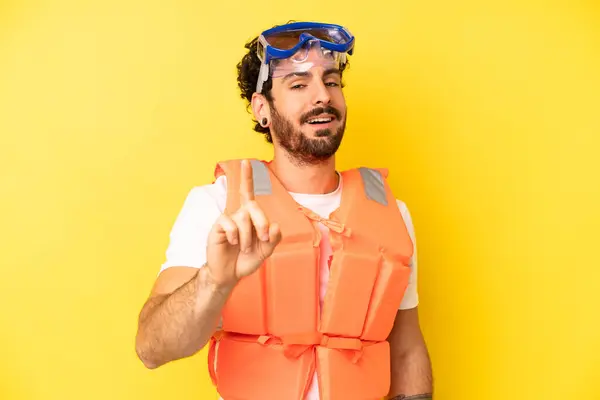 crazy bearded man smiling proudly and confidently making number one. life jacket concept