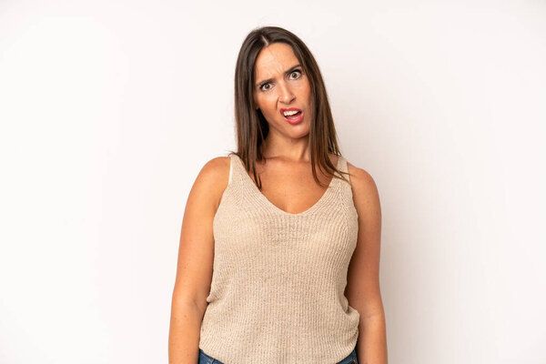 hispanic pretty woman feeling puzzled and confused, with a dumb, stunned expression looking at something unexpected