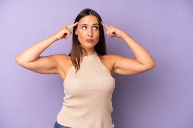 Hispanik güzel bir kadın kafası karışık ya da şüpheci, bir fikre odaklanmış, çok düşünüyor, kenarda boşluğu kopyalamak istiyor.