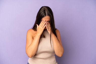 Hispanik güzel kadın üzgün, hayal kırıklığına uğramış, gergin ve depresif, iki eliyle yüzünü kaplayan, ağlayan