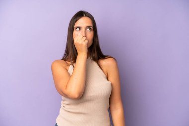 Hispanik güzel kadın ciddi, düşünceli ve endişeli, elleri çenesine bastırılmış şekilde yan bakıyor