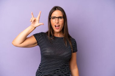 İspanyol güzel kadın kendini mutlu, eğlenceli, kendinden emin, pozitif ve asi hissediyor, elle rock veya heavy metal işareti yapıyor.