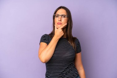 İspanyol güzel kadın ciddi, düşünceli ve güvensiz görünüyor, bir kolu çapraz ve çene üzerinde, seçenekleri tartıyor