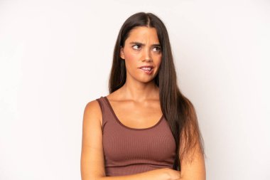 Hispanik güzel kadın şüpheye düşüyor ya da düşünüyor, dudağını ısırıyor ve kendini güvensiz ve gergin hissediyor, kenarda yer arıyor.