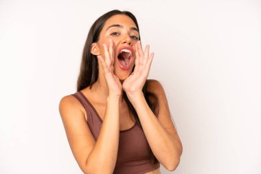 İspanyol güzel kadın mutlu, heyecanlı ve pozitif hissediyor. Elleri ağızda, bağırarak bağırıyor.