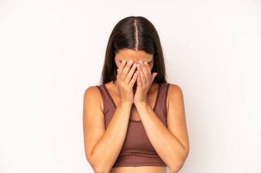 Hispanik güzel kadın üzgün, hayal kırıklığına uğramış, gergin ve depresif, iki eliyle yüzünü kaplayan, ağlayan