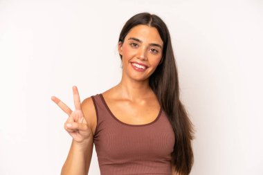 İspanyol güzel kadın gülümsüyor ve arkadaş canlısı görünüyor. İki ya da iki numarayı gösteriyor. Elleri önde, geriye doğru sayıyor.