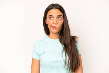 İspanyol güzel kadın şaşkın ve şaşkın görünüyor, merak ediyor veya bir sorunu çözmeye çalışıyor ya da düşünüyor.