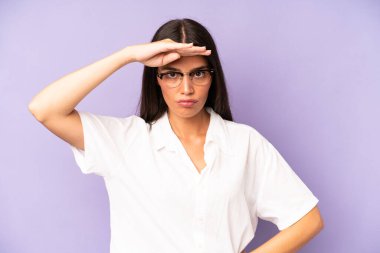 İspanyol güzel kadın şaşkın ve şaşkın bakıyor, el üstünde uzak bakıyor, izliyor ya da arıyor