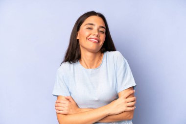 İspanyol güzel kadın kollarını kavuşturup mutlu bir şekilde gülüyor, rahat, pozitif ve tatmin edici bir pozla.