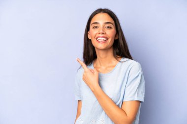 İspanyol güzel kadın heyecanlı ve şaşırmış görünüyor. Yana ve yukarı doğru uzayı gösteriyor.