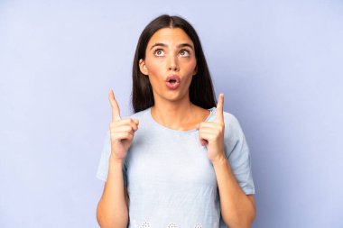 Hispanik güzel kadın şaşkınlık içinde ve ağzı açık. Şok olmuş ve şaşırmış bir bakışla yukarı bakıyor.