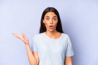 İspanyol güzel kadın şaşırmış ve şoka uğramış görünüyor, çenesi düşmüş, elinde açık bir elle bir nesne tutuyor.