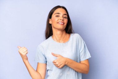 İspanyol güzel kadın neşeyle gülümsüyor ve yan taraftaki fotokopi alanını gösteriyor, mutlu ve tatmin olmuş hissediyor.