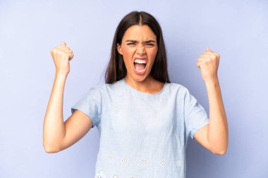 İspanyol asıllı güzel bir kadın öfkeli bir ifadeyle saldırganca bağırıyor ya da yumruklarıyla başarıyı kutluyor.