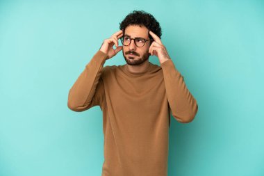 Genç sakallı adam kafası karışık ya da şüpheci hissediyor, bir fikre odaklanıyor, çok düşünüyor, kenarda boşluğu kopyalamak istiyor.