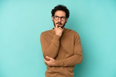 Şaşırmış, gergin, endişeli ya da korkmuş bakışları olan genç sakallı adam fotokopi uzayına bakıyor.