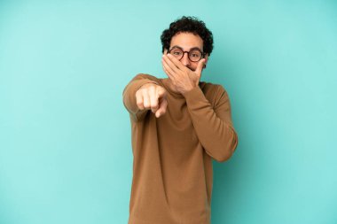 Genç sakallı adam sana gülüyor, kamerayı gösteriyor ve seninle dalga geçiyor ya da alay ediyor.