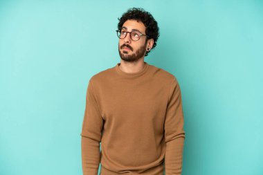 Endişeli, kafası karışık, cahil bir ifadeyle genç sakallı adam kopyalama alanına bakıyor, şüphe ediyor.