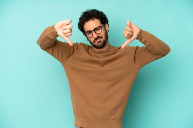 Genç sakallı adam üzgün, hayal kırıklığına uğramış ya da kızgın görünüyor, anlaşmazlık içinde parmaklarını gösteriyor, hayal kırıklığına uğramış hissediyor.